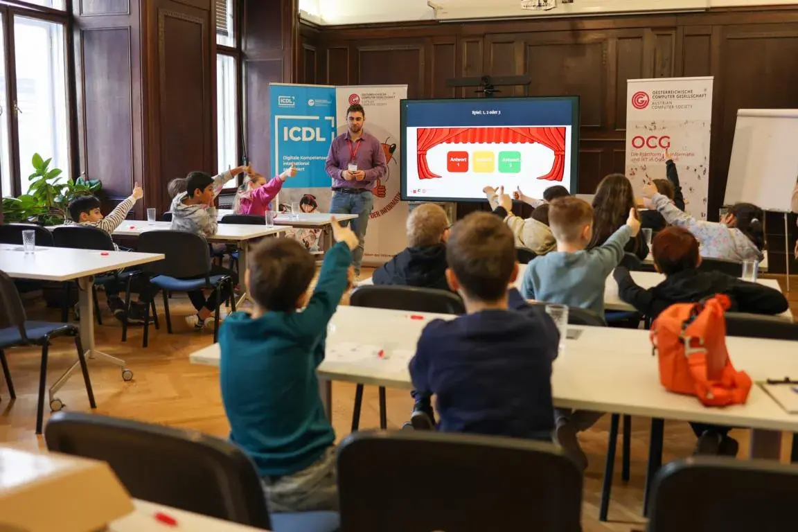 Steven Ludwig, OCG, hält einen KIDZ-Workshop zum Thema Graphen. Schüler*innen strecken Daumen nach Oben in die Luft (Abstimmung welche Frage stimmt). (c) Scheitz/OCG