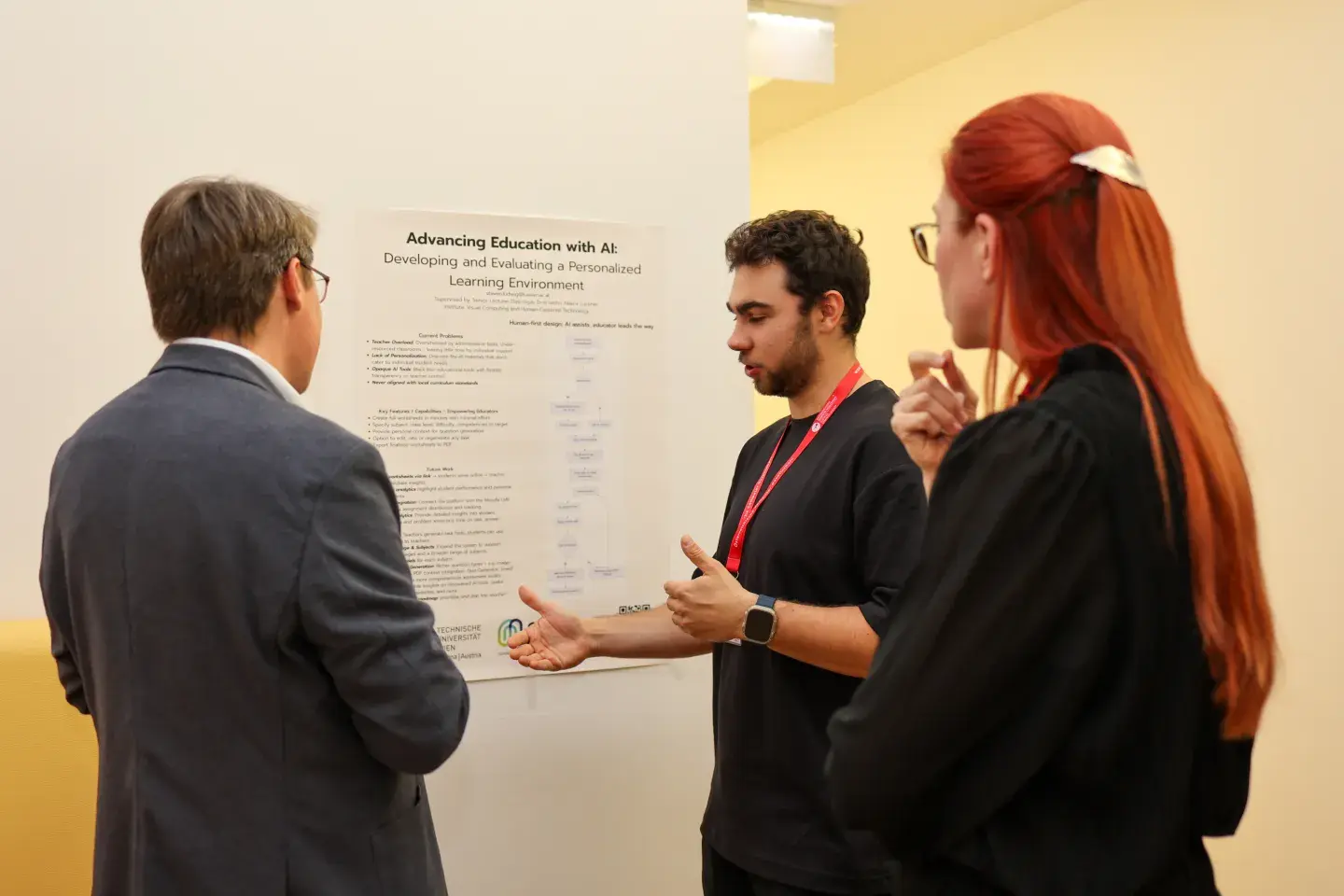 Steven Ludwig erklärt sein Poster zwei Zuhörer*innen