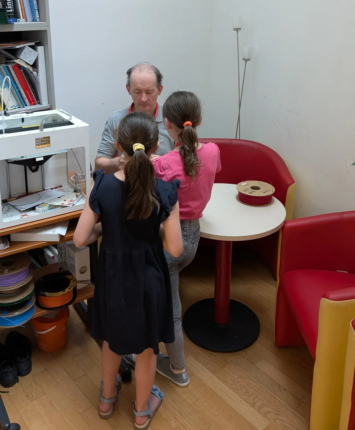 W. Baumann mit zwei Kindern beim 3D-Drucker