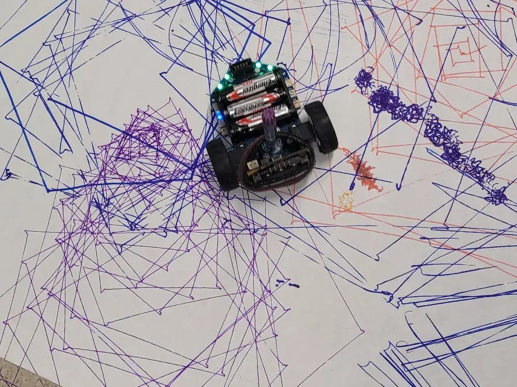 Roboter zeichnet am Boden auf Papier programmierte Muster