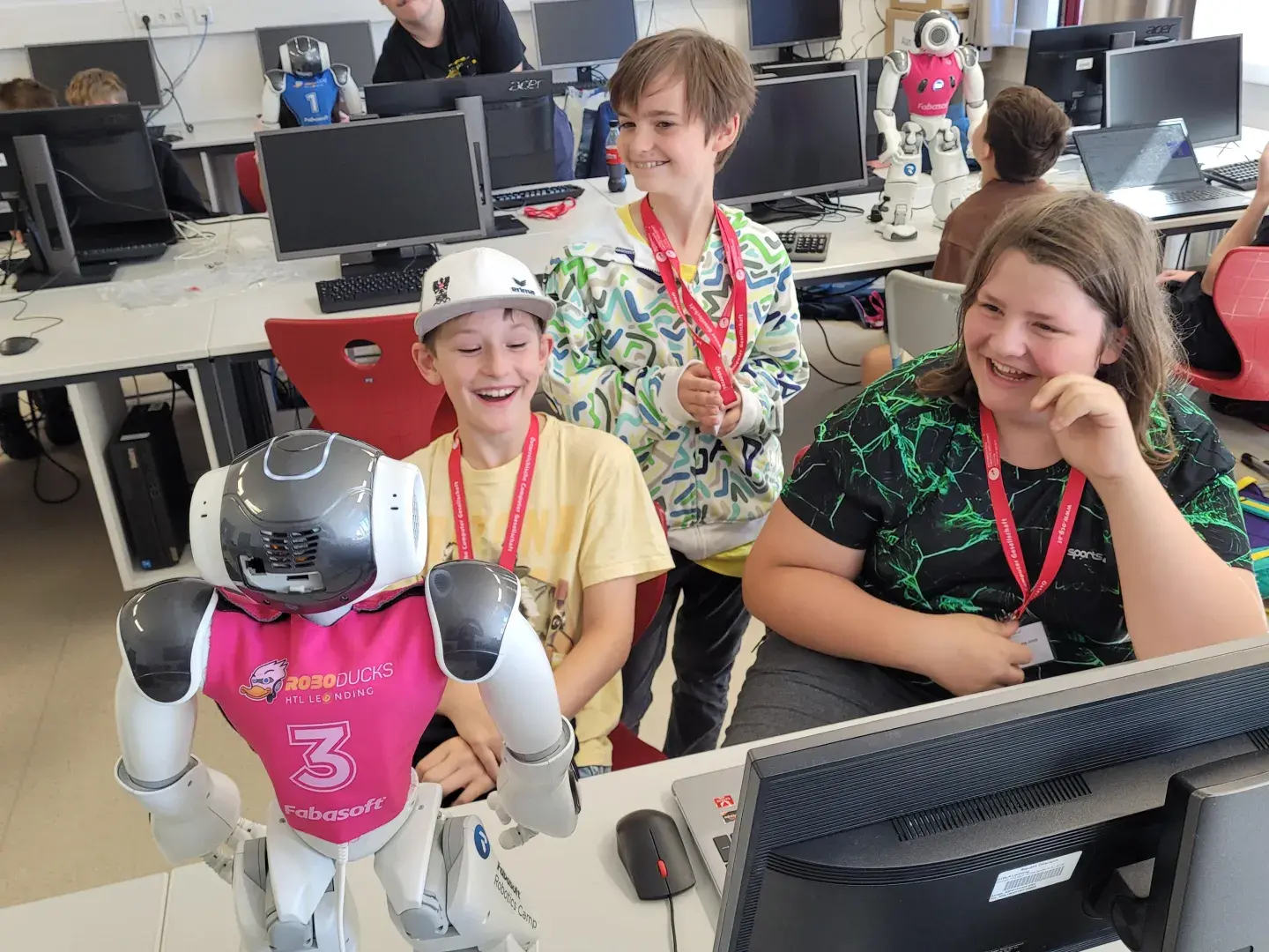 Drei Teilnehmer vom Sommercamp mit einem Roboter