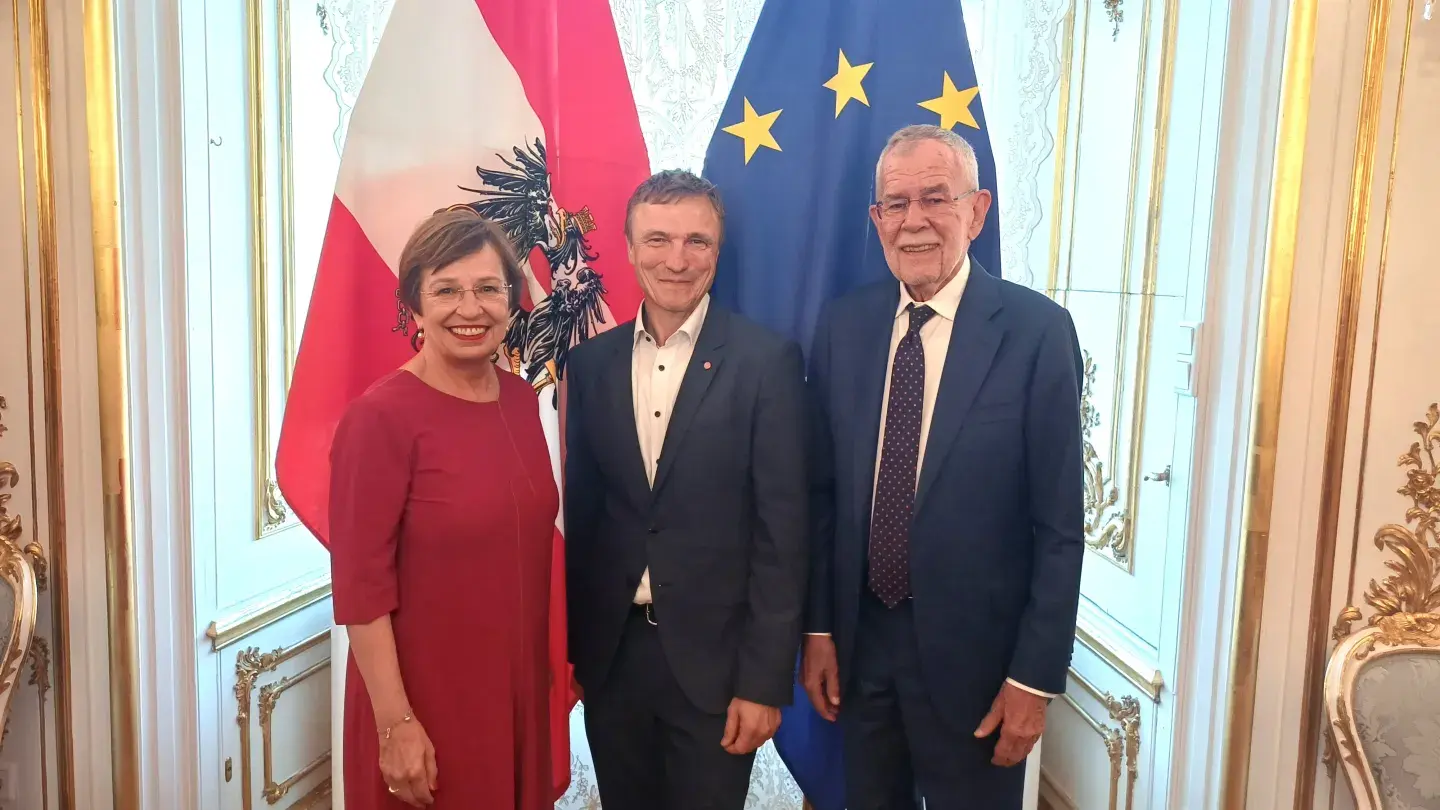 OCG-Geschäftsführer Ronald Bieber mit Doris Schmidauer und Bundespräsident Alexander Van der Bellen vor der österreichischen und EU Flagge