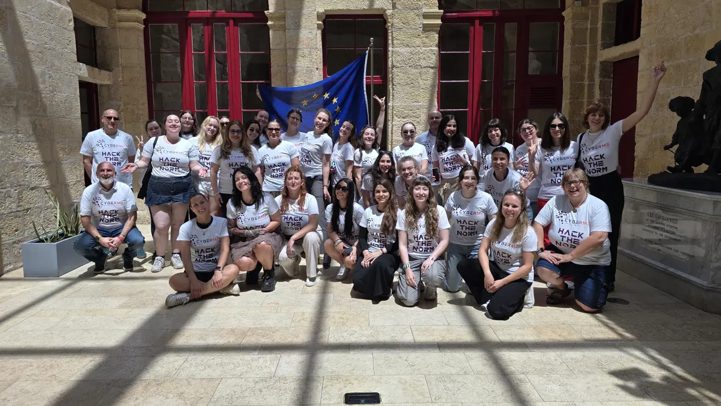 Gruppenfoto mit EU-Flagge im Hintergrund, die 24 Teilnehmerinnen des CyberMe Female Youth Cybersecurity Camps mit CyberMe Projektteam