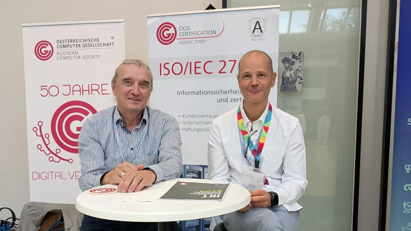 Wolfgang Resch und Christoph Jungbauer bei der IKT Sicherheitskonferenz vor dem OCG Infostand 