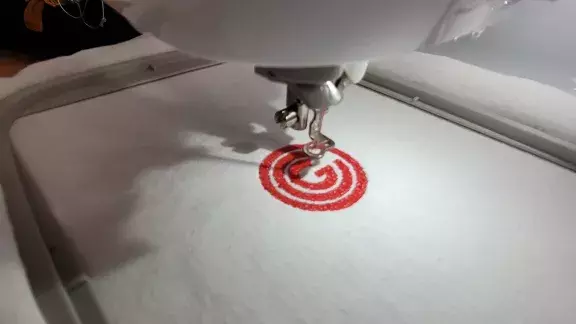 Das OCG Logo wird maschinell gestickt