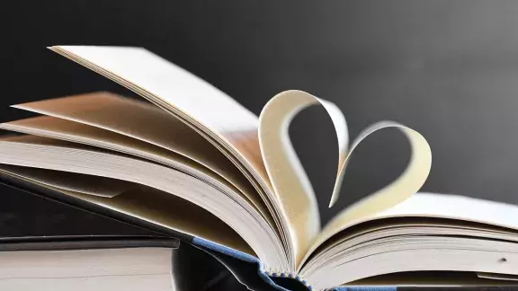Foto von einem aufgeschlagenen Buch, zwei Seiten bilden eine Herz-Form