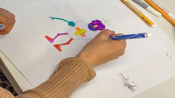 Ein Roboter wird gezeichnet: Blatt Papier mit Zeichnung, darauf eine Hand mit Stift, LNF26 in der OCG
